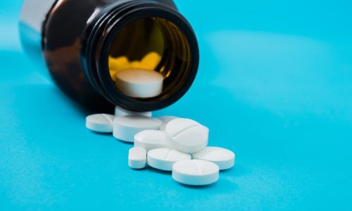 Medical pills spilling out of a toppled from pill bottle Medical pills spilling out of a toppled from pill bottle